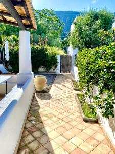 un jardin avec une passerelle en pierre et une clôture dans l'établissement Villa Euribia, à Santa Marina Salina