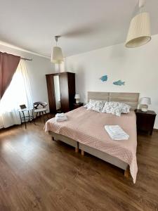 1 dormitorio con 1 cama grande con manta rosa en Rodart Morski, en Sztutowo