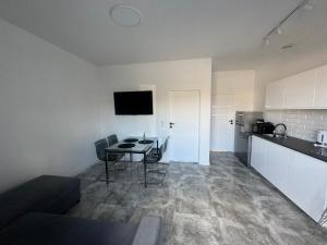 a living room with a table and a kitchen at Kamyczek in Gąski