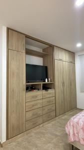 a bedroom with wooden cabinets with a television in it at K Luna Hostal Boutique in Ríohacha