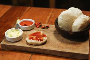a cutting board with bread and a bowl of sauce at Hostal Dos Volcanes in Malalcahuello +36 photos
