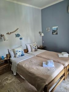 2 camas en una habitación con paredes azules en Drossinos Studios, en Poros