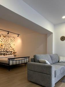 uma sala de estar com um sofá e uma cama em Vourtaréa Guesthouse em Himare