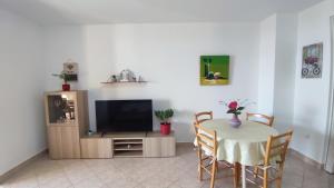 Televízia a/alebo spoločenská miestnosť v ubytovaní Apartments 3 Palms