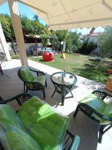 patio z krzesłami, stołem i placem zabaw w obiekcie Apartment Villa Panorama w Salonikach