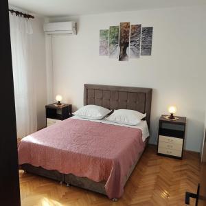 1 dormitorio con 1 cama grande y 2 mesitas de noche en Apartment Filip, en Trogir