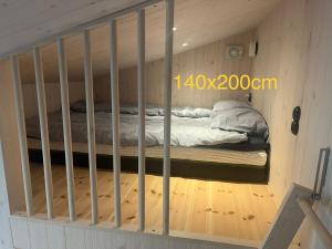 a bed in a wooden room with bars on it at Mysigt attefallshus med närhet till stad och hav in Västra Frölunda