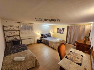 1 dormitorio con 2 camas y mesa con escritorio en Villa 5*, 15 personnes, Piscine à 20 min de Genève en Juvigny