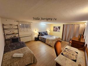 una camera da letto con due letti e un tavolo con una scrivania di Villa 5*, 15 personnes, Piscine à 20 min de Genève a Juvigny Altre 56 foto