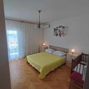 1 dormitorio con 1 cama con colcha amarilla en Apartment Filip, en Trogir