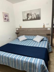 een slaapkamer met een bed met blauwe en witte lakens bij The mistral in Scilla