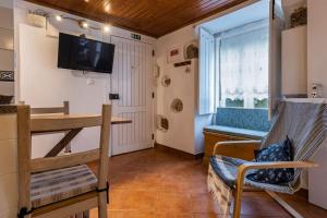 ein Wohnzimmer mit einem Tisch und einem TV an der Wand in der Unterkunft The Point - Sintra 1 in Sintra