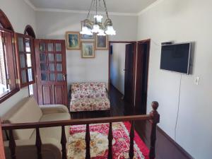 uma sala de estar com um sofá e uma televisão em Casa da Tuca em São João del Rei