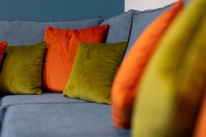 a gray couch with colorful pillows on it at Victoria Apartments in Skegness