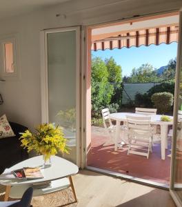 een woonkamer met een glazen schuifdeur naar een patio bij Joli appartement avec jardin dans résidence avec piscines in Agay - Saint Raphael