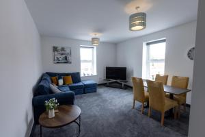 a living room with a blue couch and a table at Victoria Apartments in Skegness