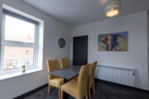 a dining room with a table and chairs and a window at Victoria Apartments in Skegness
