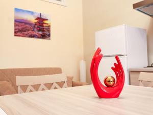 een rode vaas op tafel met een bal erin bij Casa Vacanze Michelangelo in Letojanni