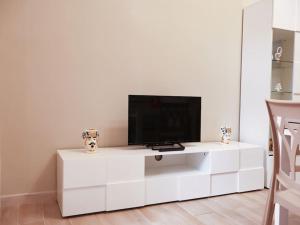 een wit entertainmentcentrum met een flatscreen-tv erop bij Casa Vacanze Michelangelo in Letojanni