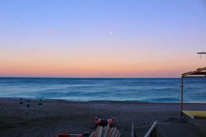 een strand met stoelen en de oceaan bij zonsondergang bij Casa Vacanze Michelangelo in Letojanni