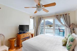 a bedroom with a bed and a television and a balcony at Kuapa Isle Gem Unit 419 in Honolulu