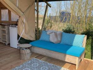 a blue couch sitting on a deck in a gazebo at De Tijnjehoeve in Boornzwaag