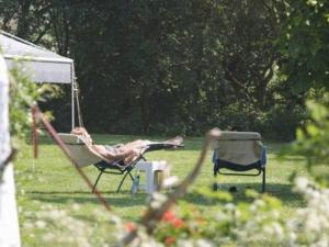a person laying in a chair in a yard at De Tijnjehoeve in Boornzwaag