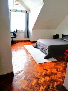 ein Schlafzimmer mit einem Bett auf einem Holzboden in der Unterkunft Spacious Ensuite Room Kilimani in Nairobi