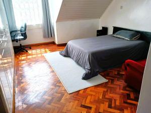 Schlafzimmer mit einem Bett, einem Schreibtisch und einem Stuhl in der Unterkunft Spacious Ensuite Room Kilimani in Nairobi
