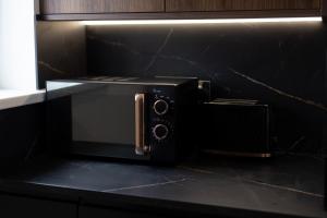 a black microwave oven sitting on top of a counter at Victoria Apartments in Skegness