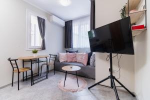 a living room with a couch and a tv at City Center Studio Apartments in Plovdiv