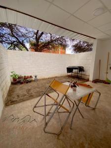 a table and chairs in a room with a piano at La acequia casa in Cafayate