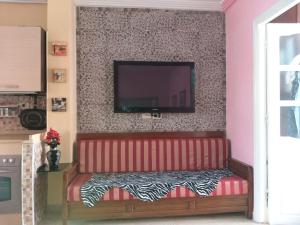 - un canapé rouge avec une télévision murale dans l'établissement Nour, à Sousse