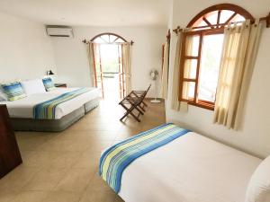 Un dormitorio con 2 camas y una silla. en Hotel Galapagos Suites B&B, en Puerto Ayora