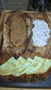 una tabla de cortar de madera con tortillas y salsa en A&S House en Siwa