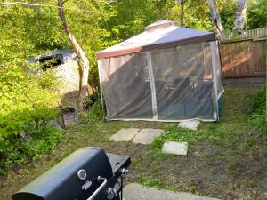 a tent in a yard next to a fence at Oshawa Downtown, 2 Bed rooms house fully furnished in Oshawa