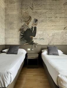two beds sitting next to each other in a room at Sole Mare in Ventimiglia