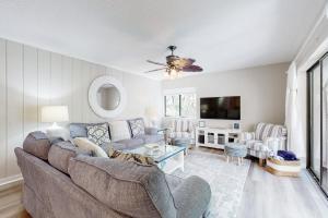 uma sala de estar com um sofá e uma televisão em 2023 Beach Wood em Fernandina Beach