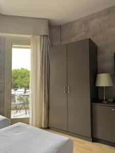1 dormitorio con 1 cama, armario y ventana en Sole Mare, en Ventimiglia