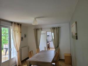 a dining room with a wooden table and a window at Gîte Saint Ambroise Mont Saint-Michel in Bacilly