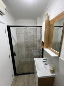 W łazience znajduje się biała umywalka i prysznic. w obiekcie Paradiso1 w mieście Vračar (historical)