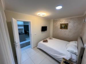 a bedroom with a white bed and a television at Paradiso1 in Vračar (historical)