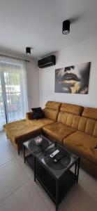 a living room with a brown couch and a table at Apartament JB 56m2 parking,balkon,2sypialnie in Legnica
