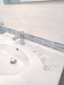 a white bathroom sink with a faucet at Villa Florence apartment con parcheggio in Torre Lapillo