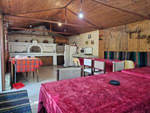 a kitchen and dining room with two tables and a kitchen with at Хижа "Миньор" in Burgas