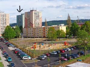 a parking lot with parked cars and a playground at apartmán Aneta in Karlovy Vary