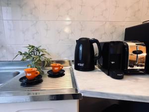a coffee maker and two cups on a kitchen counter at Royal Jelly Suites in Marathias