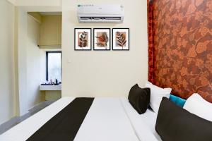 sypialnia z białym łóżkiem i czerwoną ścianą w obiekcie OYO Hotel Mid Town w mieście Bilaspur