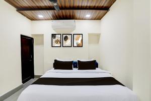 um quarto com uma cama branca e um tecto de madeira em OYO Hotel Mid Town em Bilāspur
