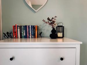 uma prateleira com livros e um vaso com flores em Royal Jelly Suites em Marathias